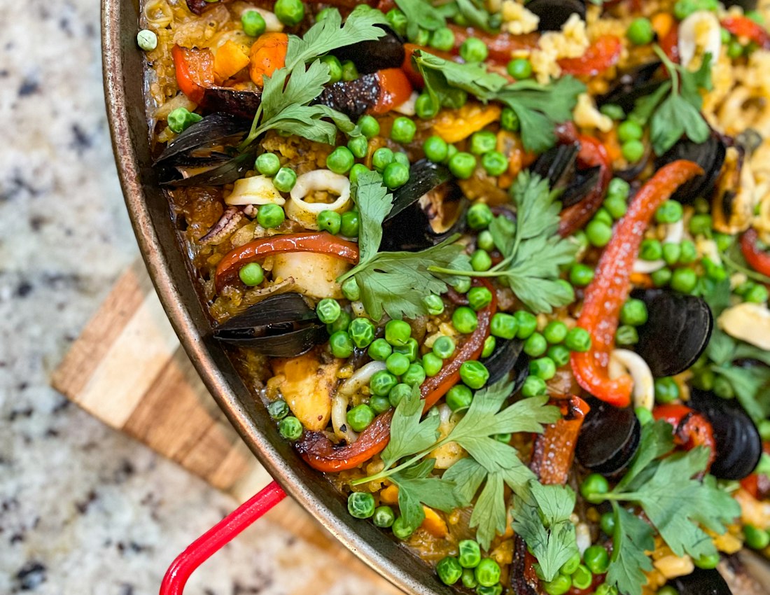 A freshly made seafood paella with peas and peppers