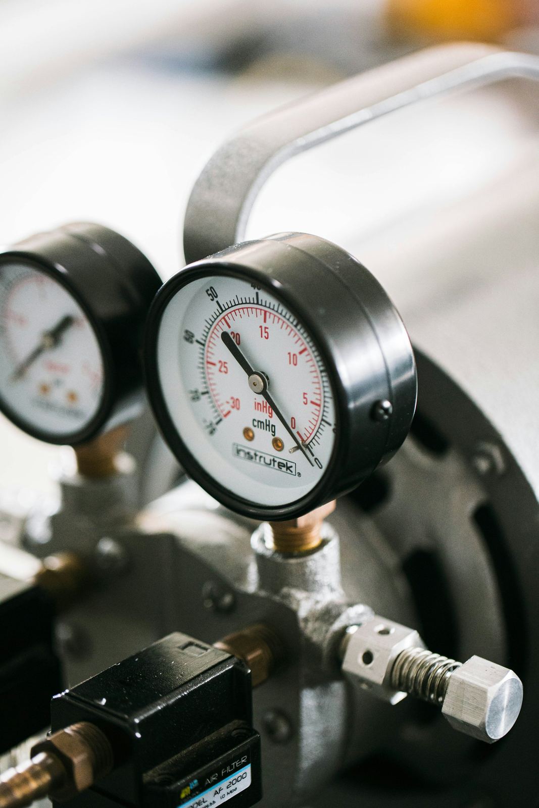 Close-up of two pressure gauges connected to a unit