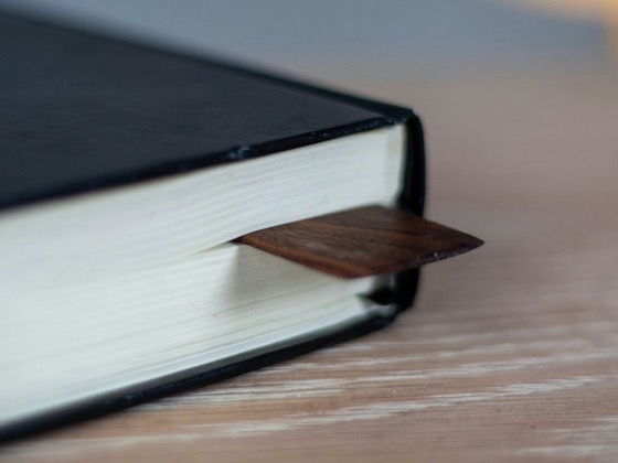 Кут книжки в чорній твердій палітурці з дерев’яною закладкою