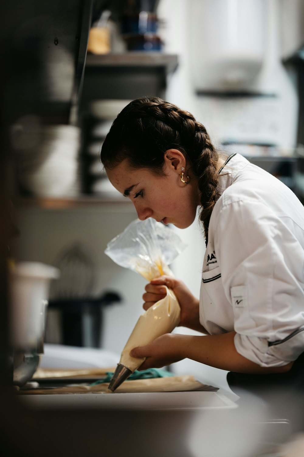 Daria, pastry chef, decorating with a piping bag in a professional kitchen
