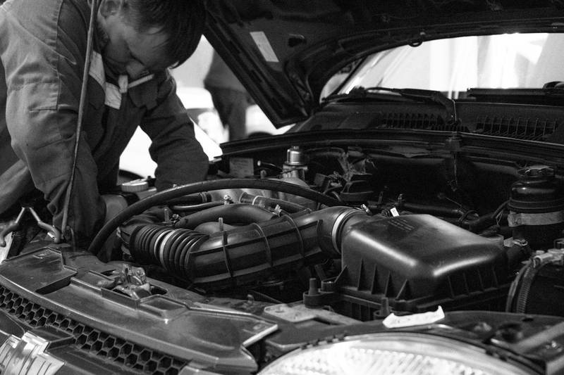 Mechanic checking the engine with the bonnet up